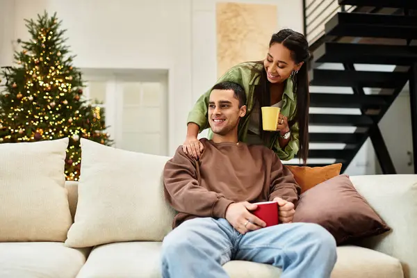 A couple enjoys each other company in their modern, decorated living space for Christmas. — стоковое фото