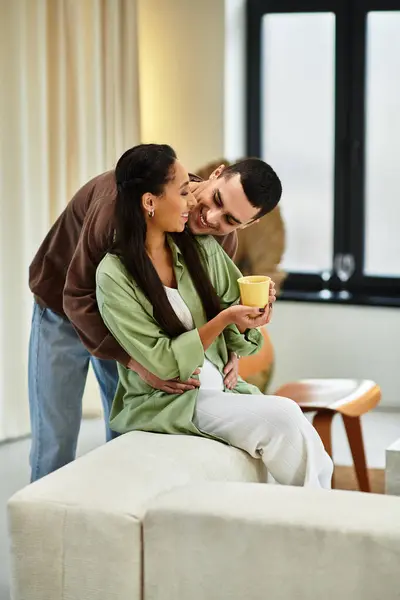 Un beau couple partage des moments chaleureux tout en célébrant Noël dans leur salon chic. — Photo de stock