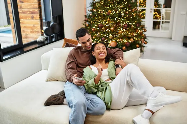 Couple relaxes together in a stylish apartment, surrounded by festive decorations and love. — Stock Photo