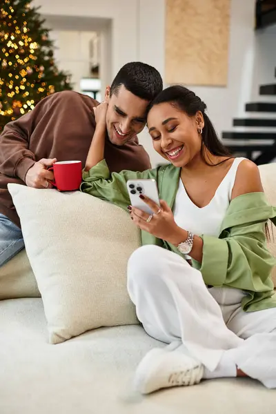 A couple relaxes and laughs while sharing joyful moments in their decorated home for Christmas. — Stock Photo