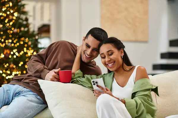 A couple shares laughter and warmth in a stylish living room filled with Christmas cheer. — Stock Photo