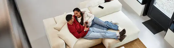 Um casal desfruta de momentos acolhedores em um sofá em seu apartamento alegre e festivo, banner — Fotografia de Stock