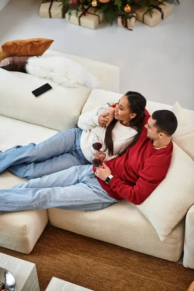 Dos personas encantadoras disfrutan de bebidas juntas en medio de la decoración navideña festiva. - foto de stock