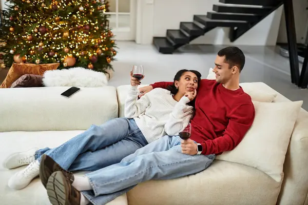 A loving couple enjoys a cozy evening together, sipping wine and celebrating the holidays. — Stock Photo