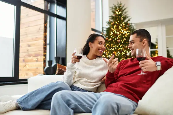 A couple sips wine together in a beautifully decorated Christmas setting. — Stock Photo
