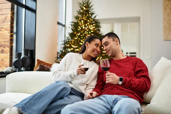 Una bella coppia si gode la compagnia sorseggiando vino nel loro spazio di vita festivo. — Foto stock