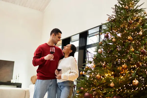 A couple shares laughter and love in a cozy, decorated apartment filled with holiday cheer. — Stock Photo