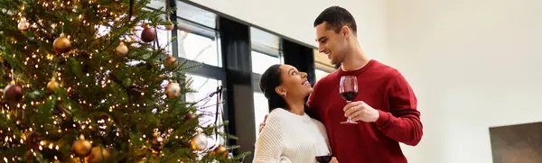 Una pareja disfruta de la compañía de los demás junto al vibrante árbol de Navidad, compartiendo risas y alegría, pancarta - foto de stock