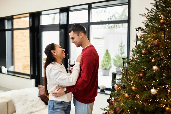 A couple embraces joyfully while celebrating Christmas in their stylishly decorated home. — Stock Photo