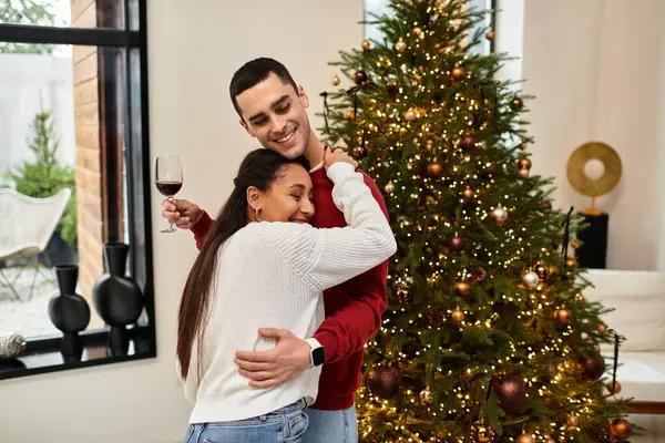 Hermosa pareja disfruta de alegría navideña en un elegante apartamento lleno de decoraciones festivas. - foto de stock