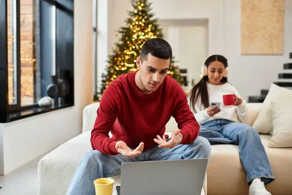Ein Paar entspannt sich in seiner stilvollen Wohnung und feiert Weihnachten mit Wärme und Freude. — Stockfoto