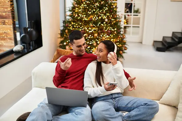 Paar entspannt zusammen in einem dekorierten Wohnzimmer und umarmt die Urlaubsstimmung mit Freude. — Stockfoto