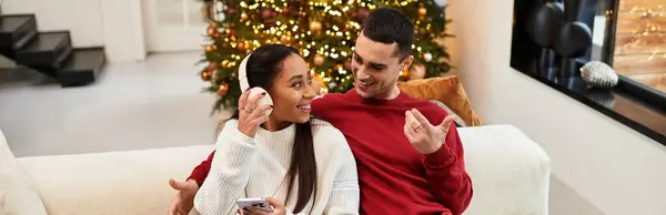 Ein Paar genießt einen schönen Moment zusammen in einem festlich geschmückten, weihnachtlich geschmückten Wohnzimmer. — Stockfoto