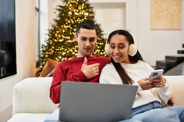 A beautiful couple shares joyful moments in their decorated apartment, embracing the holiday spirit. — Stock Photo