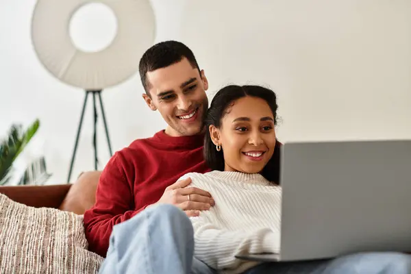 Un beau couple profite de l'autre compagnie tout en naviguant ensemble sur un ordinateur portable. — Photo de stock