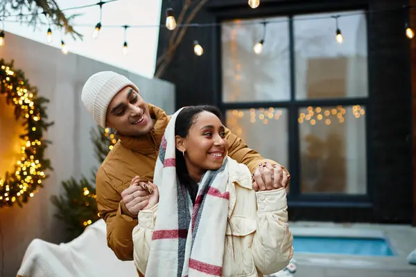 A beautiful couple shares a joyful winter day outdoors, surrounded by festive decorations. — Stock Photo