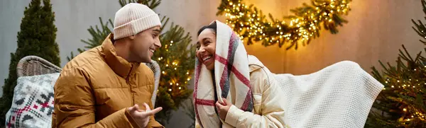 Couple enjoys quality time together outdoors, wrapped in a blanket amidst festive decorations, banner — Stock Photo