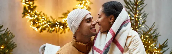 Couple enjoys a tender moment outdoors, wrapped in cozy winter layers surrounded by holiday cheer, banner — Stock Photo