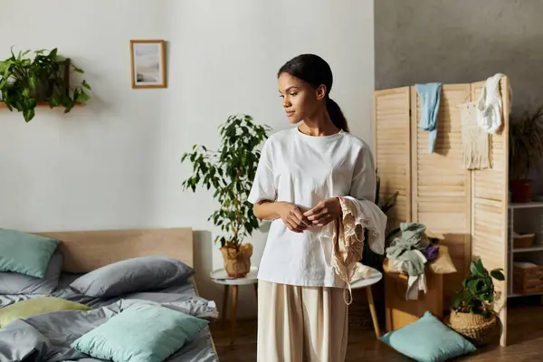 En un apartamento elegante, una joven organiza su espacio mientras maneja tareas de limpieza. - foto de stock