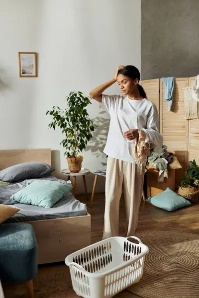 In a cozy apartment, a young African American woman organizes her space with care and focus. — Stock Photo