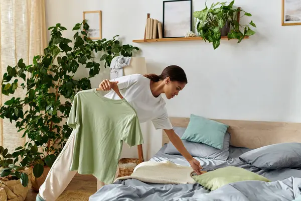 Eine junge Afroamerikanerin organisiert ihr Schlafzimmer, während sie putzt und die tägliche Arbeit genießt. — Stockfoto