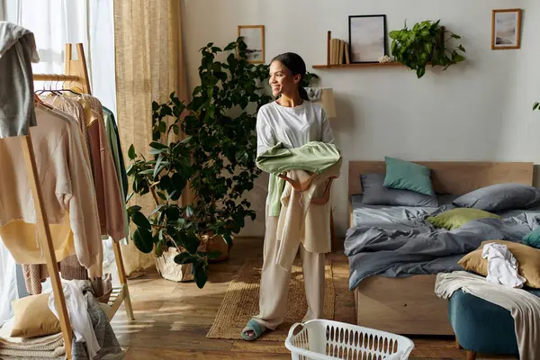 In a bright apartment, a young African American woman tidies up, embracing her chores with joy. — Stock Photo