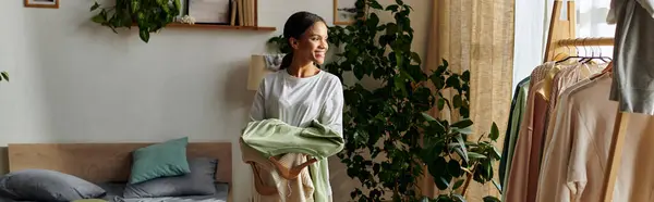 Helle und luftige Wohnung, in der eine junge Frau Wäsche organisiert und schön aufräumt, Banner — Stockfoto