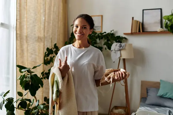 Una joven negra gestiona alegremente sus tareas de limpieza en un apartamento elegante mientras sonríe. - foto de stock