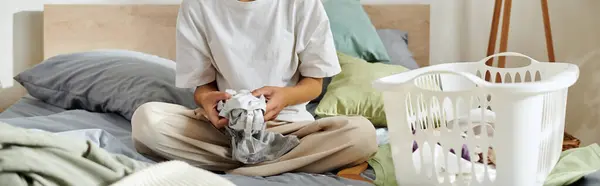 A young African American woman is folding laundry in her cozy modern apartment, banner — Photo de stock