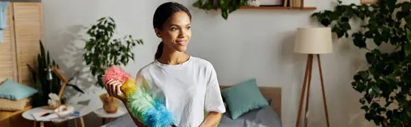 Uma jovem afro-americana gosta de limpar seu elegante apartamento, mostrando seu espírito vibrante, bandeira — Fotografia de Stock