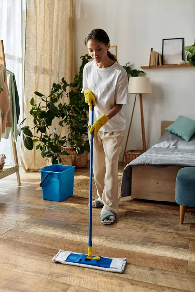 A young African American woman dressed comfortably cleans her living space with care. — Stock Photo