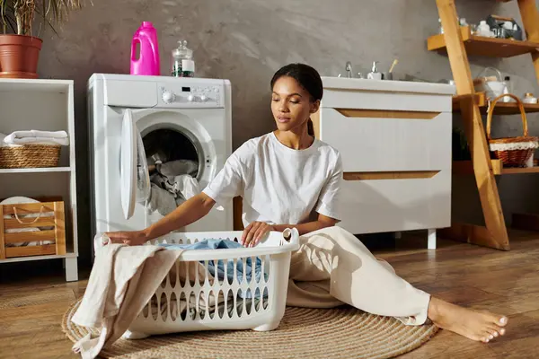 In a stylish apartment, a young woman sorts laundry with a sense of calm and focus. — Photo de stock