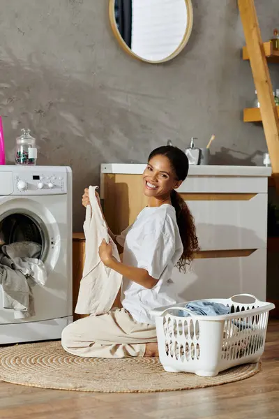 A young Black woman happily handles chores in her stylish apartment. — Stock Photo