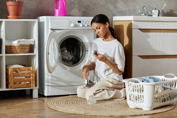 Eine junge Afroamerikanerin putzt und organisiert Wäsche in einer schicken Wohnung. — Stockfoto
