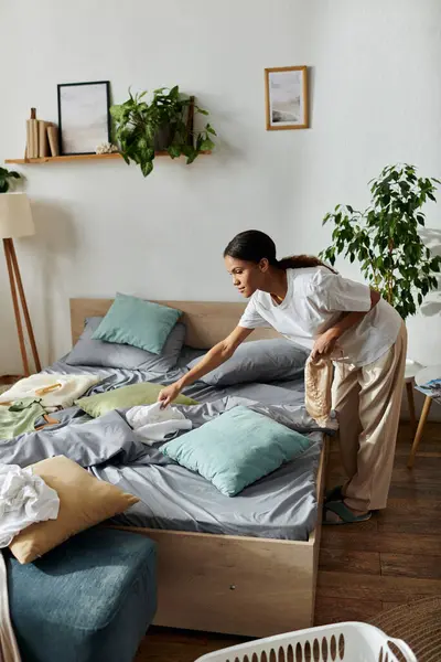 Young woman diligently organizes her modern apartment while completing daily chores. — стоковое фото