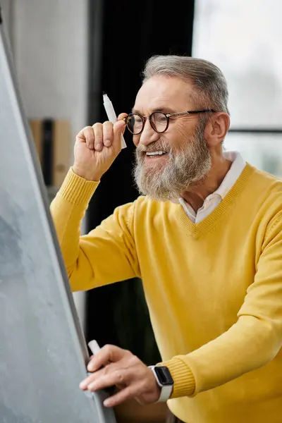 Handsome senior man expresses creativity while sketching in a contemporary workspace. — Stock Photo