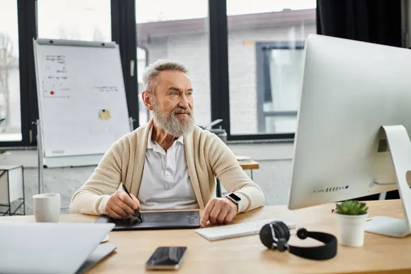 Senior man in casual attire focused on digital work at his stylish home office workspace — Stock Photo