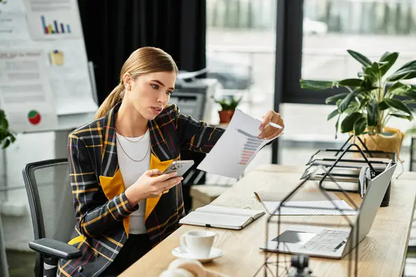 A young woman analyzes reports on her smartphone in a sleek office. — Stock Photo