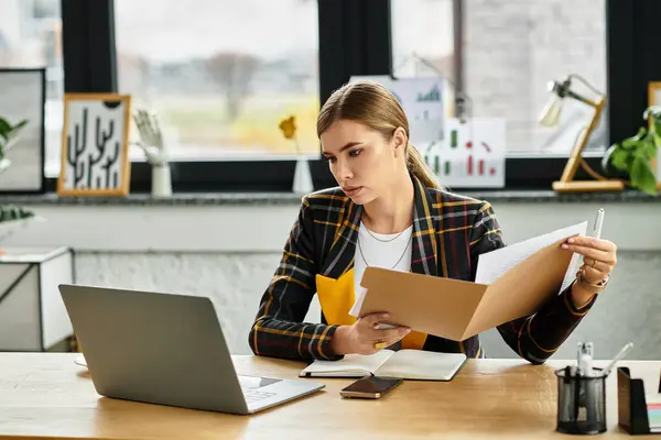 Attractive businesswoman in checkered blazer focuses on task at her contemporary desk. — Stock Photo