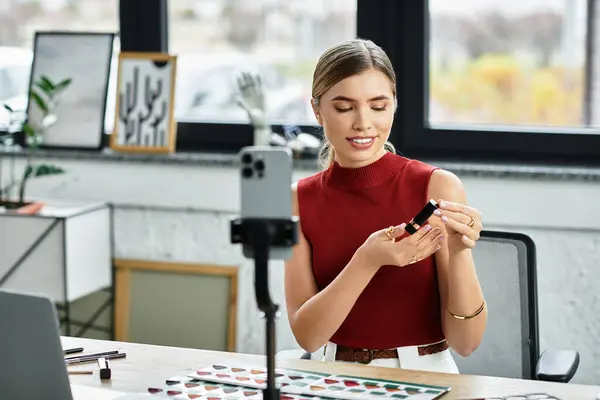 Millennial influenceur engage les téléspectateurs tout en mettant en valeur les produits de beauté sur son smartphone. — Photo de stock
