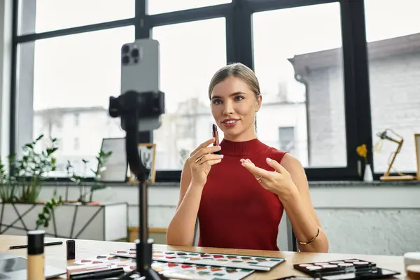Attractive young influencer engages viewers by demonstrating beauty products during a livestream. — Stock Photo