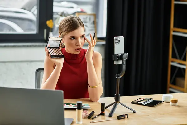 Une jeune influenceuse démontre ses produits de beauté préférés tout en s'engageant avec les téléspectateurs en ligne. — Photo de stock