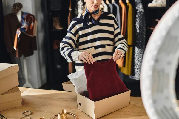 Young woman organizes fashionable clothing and shares styling tips from a boutique. — Stock Photo