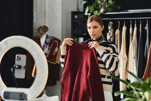 Attractive young woman records her fashionable outfit creations in a vibrant studio space. — Stock Photo