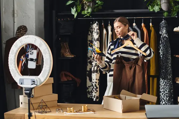A young woman explores trendy outfits and records her fashion insights with a smartphone. — Stock Photo