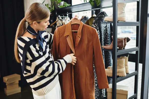 An attractive young woman browses chic clothing in a trendy boutique — Stock Photo