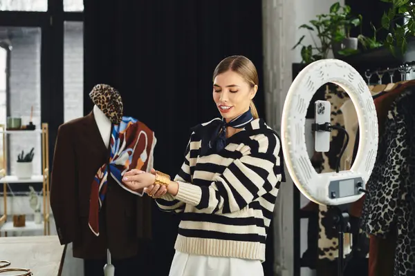Attractive young woman styles outfits in a chic studio while vlogging about fashion trends. — Stock Photo