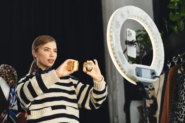 Young fashion stylist showcases chic attire and records outfit ideas using her smartphone. — Stock Photo