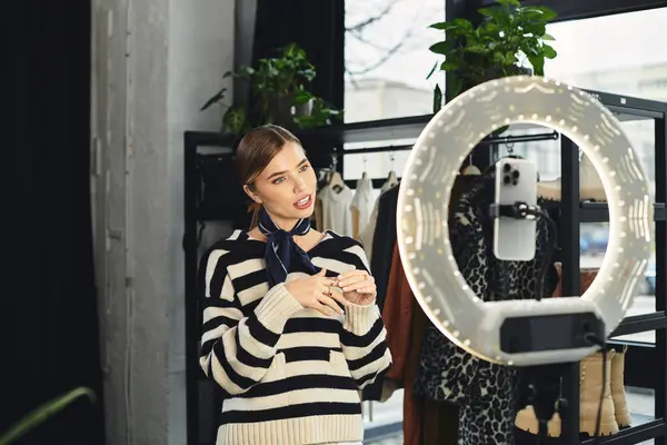 An attractive woman records her fashion ideas on a smartphone in a modern setting. — Stock Photo