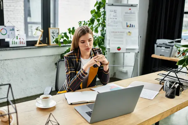 Mulher de negócios elegantemente vestida se concentra intensamente em seu laptop enquanto trabalha em relatórios. — Fotografia de Stock